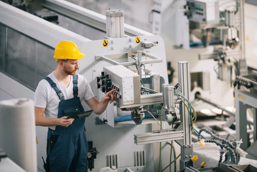 Un homme avec un casque travaillant dans une usine.