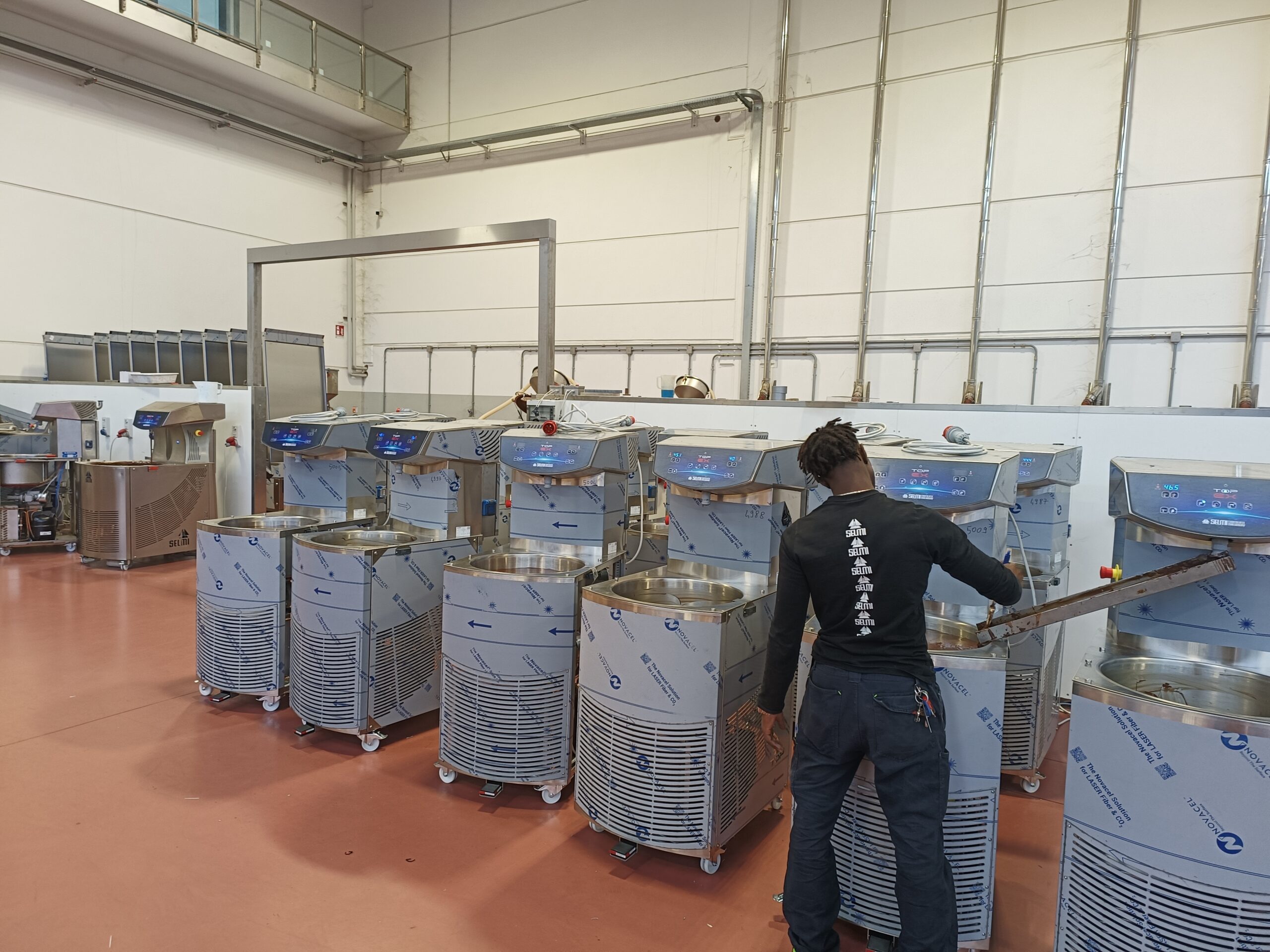 Technicien travaillant sur une tempéreuse Selmi dans un laboratoire de production de chocolat industriel.