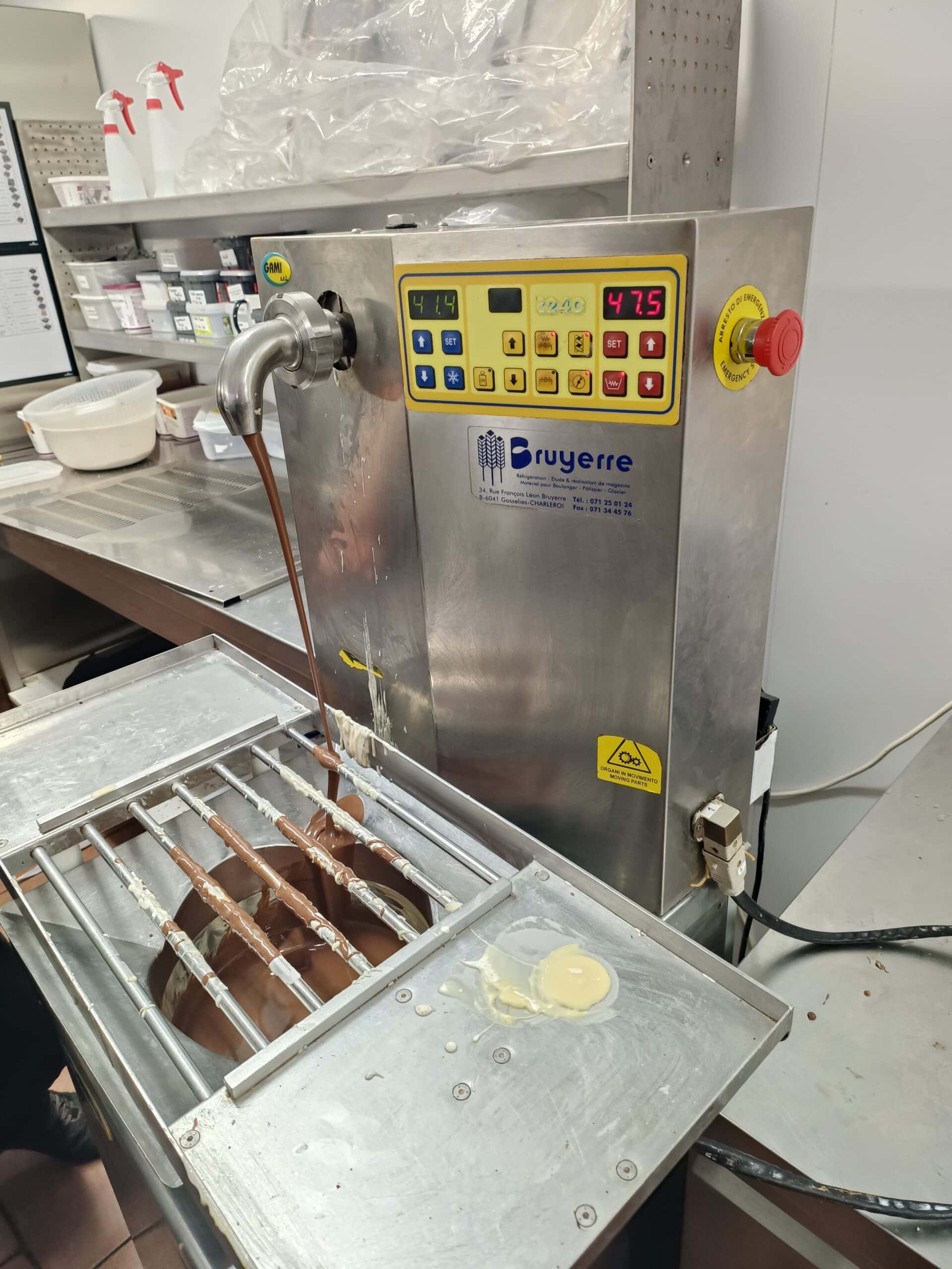 Tempéreuse à chocolat Bruyerre versant du chocolat fondu sur une grille dans un atelier de pâtisserie.